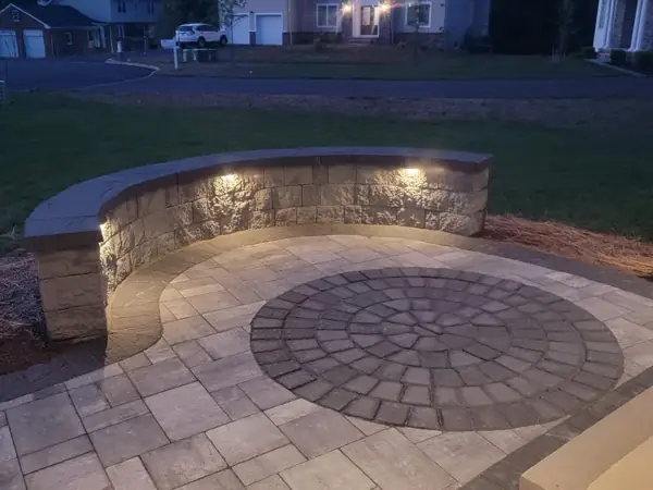 Circle-kit paver patio with lit seat wall